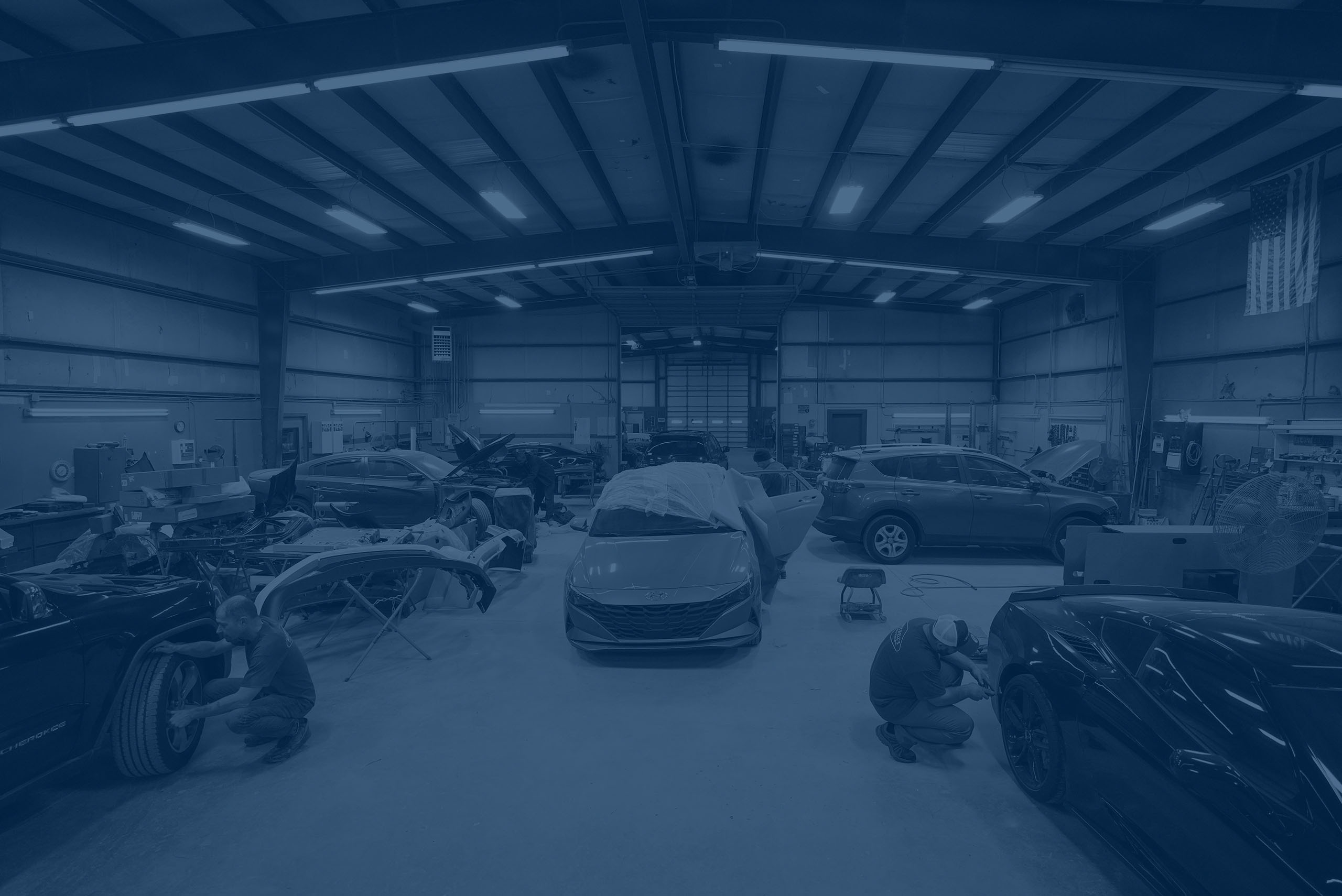 Wide angle view of garage, workers fixing vehicles